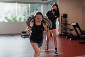 Woman lunging with weight while trainer supervises | Photo by TSquared Lab